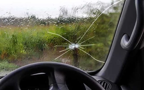 Car windscreen with crack above steering wheel Car windscreen with crack above steering wheel
