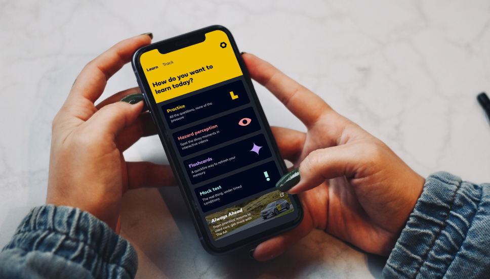 Theory app A person holding a smart phone using a driving theory test revision app