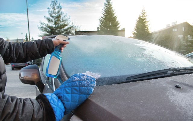 man with windscreen deicer and ice scraper man with windscreen deicer and ice scraper
