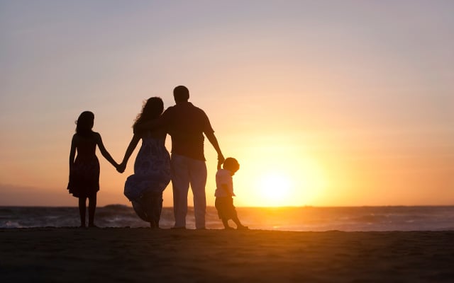Silhouette family on beach sunset