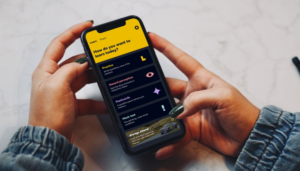 A person holding a smart phone using a driving theory test revision app